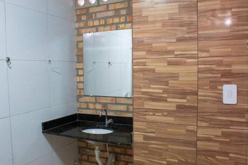 a bathroom with a sink and a mirror at Chalé dos Felipe's in Nísia Floresta