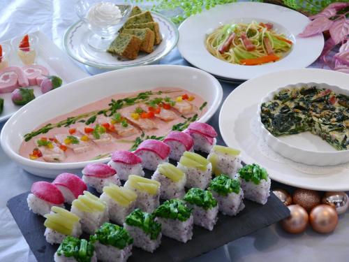 a table with plates of sushi and bowls of food at Biei Shirogane Onsen Hotel Park Hills in Biei