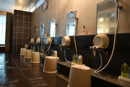 a bathroom with a row of sinks and mirrors at Biei Shirogane Onsen Hotel Park Hills in Biei