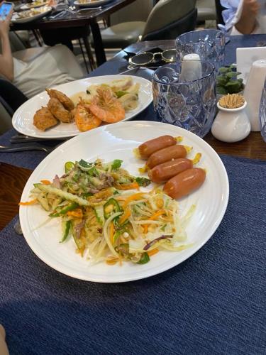 a plate of food with sausages and noodles on a table at Tamcoc Motel in Văn Lâm