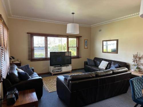 a living room with couches and a flat screen tv at Koonwarra Holiday Park in Lakes Entrance