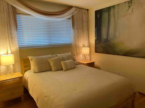 a bedroom with a bed with two lamps and a window at Redwood Garden in Sacramento