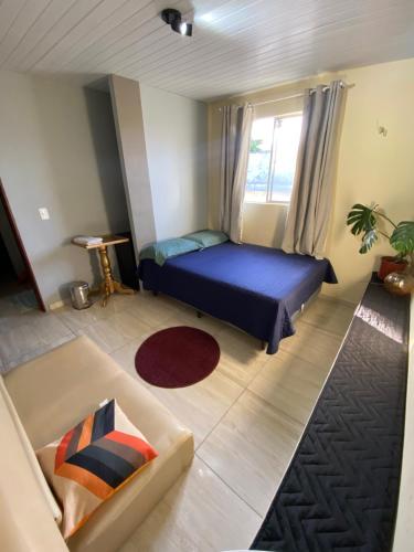 a bedroom with a blue bed and a window at Quarto - Nosso lar em Natal in Natal