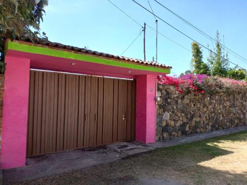 a building with a wooden gate and a stone wall at AranCalli, hospedaje en cabañas in Ozumba de Alzate