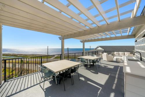 a patio with tables and chairs on a balcony at The Surf Ranch by Pristine Properties Vacation Rentals in Port Saint Joe