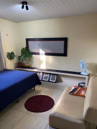 a room with a bed and a couch and a flag at Quarto - Nosso lar em Natal in Natal