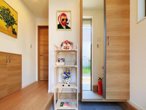 a room with a door and a shelf with flowers at SKYE HOMEⅡ本羽田 in Tokyo
