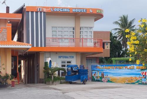 a hotel with a blue truck parked in front of it at RedDoorz at JL Lodging House and Cafe Irosin in Irosin