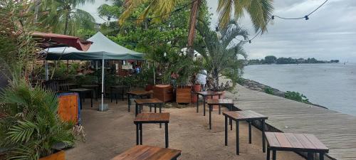 a row of benches and tables on a dock near the water at Kimmy Tahiti House in Punaauia