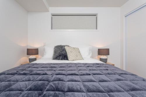 a bedroom with a large bed and two lamps at Central Apartment Stone Throw from Hospital in Addington