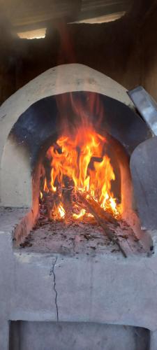 a pizza oven with a fire in it at Pachamama Hospedaje & Restaurant Pitumarca in Checacupe