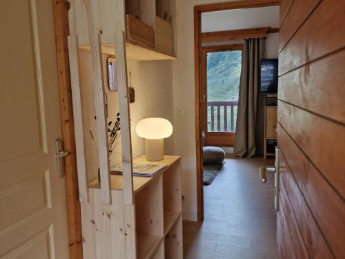 a room with a door and a table with a lamp at Appartement cosy 6 pers, au pied des pistes avec balcon et WiFi - FR-1-178-386 in Les Bruyères