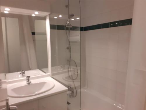 une salle de bain blanche avec un lavabo et une douche dans l'établissement Appartement confortable 2 pièces avec balcon, proche télécabine et commerces à Valfréjus - FR-1-561-114, à Modane