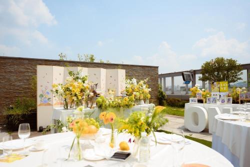 a table with vases filled with flowers on it at Courtyard By Marriott Seoul Times Square in Seoul