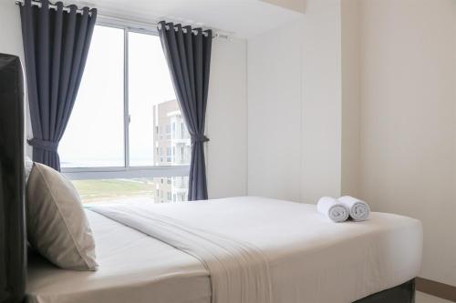 a bedroom with a bed with two towels on it at Cozy and Enjoy Living 2BR at Tokyo Riverside PIK 2 Apartment By Travelio in Rawalembang