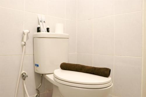 a white toilet in a bathroom with a phone at Cozy and Enjoy Living 2BR at Tokyo Riverside PIK 2 Apartment By Travelio in Rawalembang