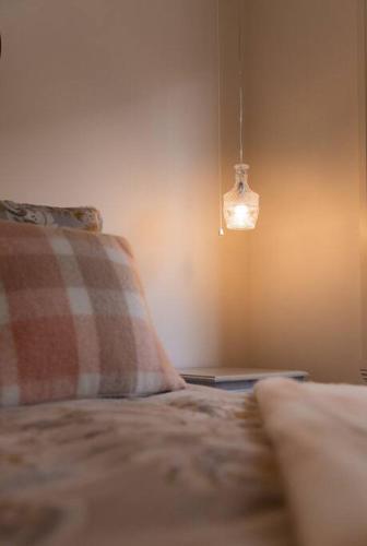 a bedroom with a bed with a pillow and a light at Tides & Tails - Pet Friendly in Scamander