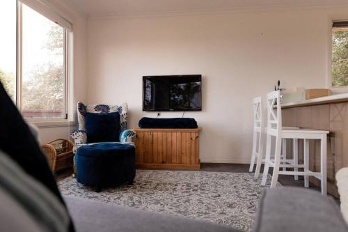 a living room with a flat screen tv on a wall at Tides & Tails - Pet Friendly in Scamander