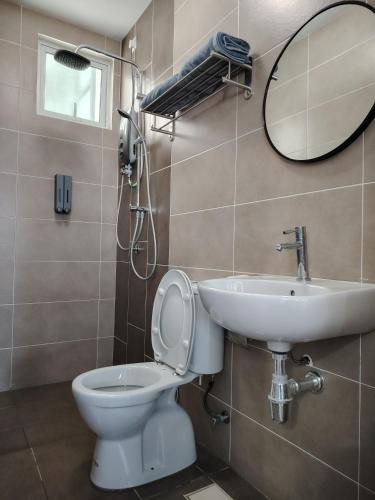 a bathroom with a sink and a toilet and a mirror at J&K Guesthouse at Palmyra Residence in Kajang