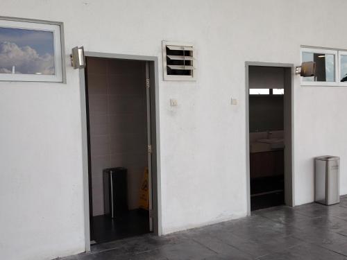 an open door in a white room with a sink at J&K Guesthouse at Palmyra Residence in Kajang