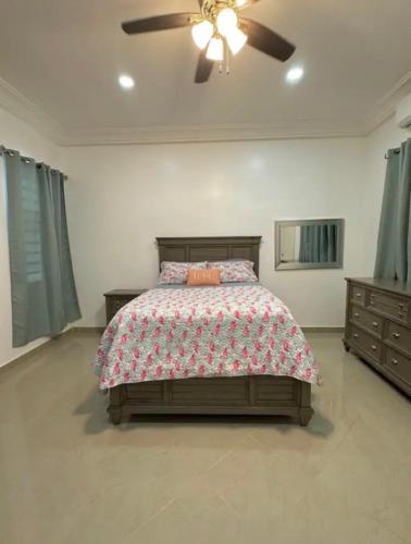 Un dormitorio con una cama y un ventilador de techo. en Tranquil Haven Villa, en Kumasi