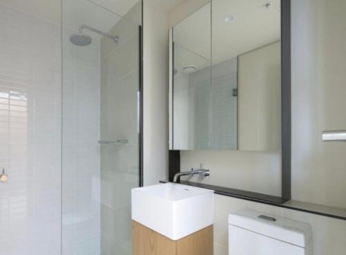 a bathroom with a white sink and a mirror at Apartment 405 8 Daly St South Yarra 3141 LUCIA in Melbourne