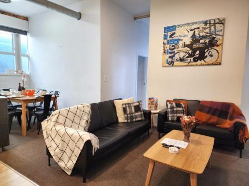a living room with a black couch and a table at U Suites on Webb in Wellington