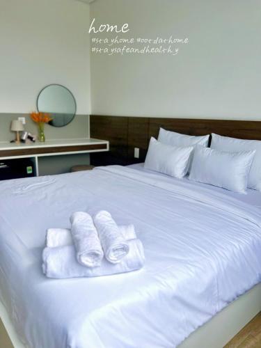 a white bed with three folded towels on it at Hoàng Khang Hotel- Khách Sạn Buôn Ma Thuột in Buôn Kô Sir