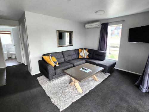 a living room with a couch and a table at Lugano Motor Lodge in Blenheim