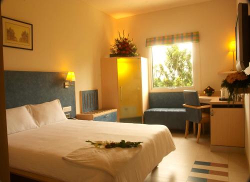 a hotel room with a bed and a couch at Radha Hometel in Bengaluru