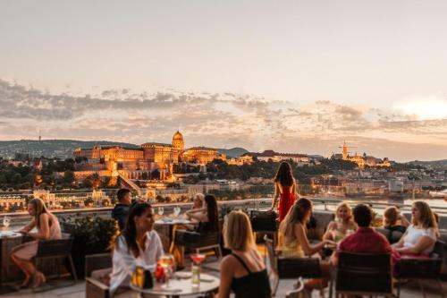 a group of people sitting at a restaurant with a view at Budapest Marriott Hotel in Budapest