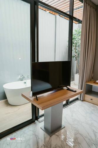 a television sitting on a table in a bathroom at Blooming resort buriram บลูมมิ่ง รีสอร์ท บุรีรัมย์ in Ban Makha