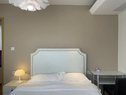 a bed with a white headboard in a bedroom at Shanghai Lerongju Boutique Apartment Metro Line 8 20meter in Shanghai