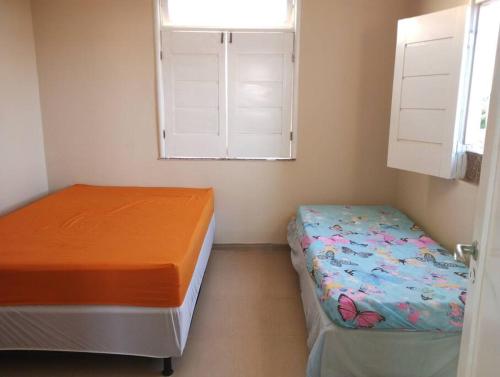 a bedroom with two beds and a window at Casa na Praia Caueira Sergipe in Praia Da Caueira