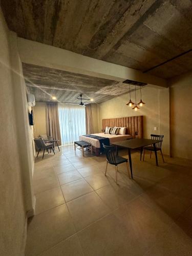 a living room with a table and chairs and a bed at Lolitas Suites 303 in Zihuatanejo