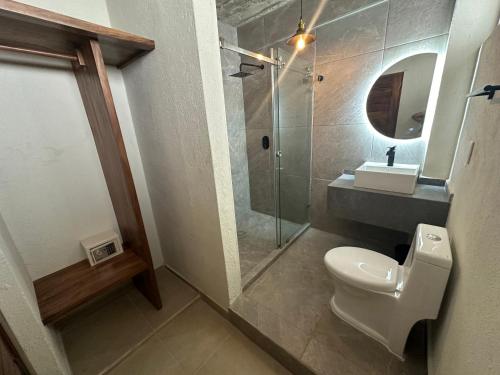 a bathroom with a shower and a toilet and a sink at Lolitas Suites 303 in Zihuatanejo