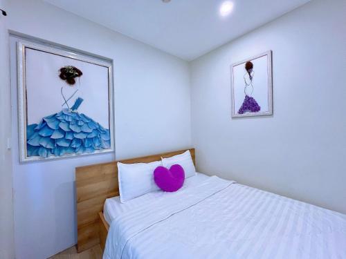 a bedroom with a white bed with a pink heart pillow at PƠ Homestay THESONG Vũng Tàu in Vung Tau