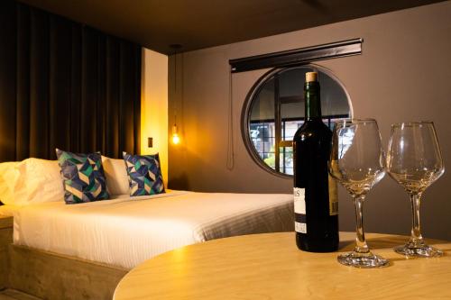 a bottle of wine sitting on a table with two wine glasses at Los Patios Cool Living in Medellín
