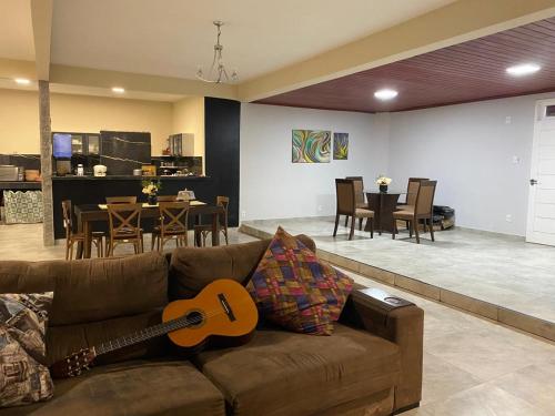 a guitar sitting on a couch in a living room at Praia das Dunas SE in Estância