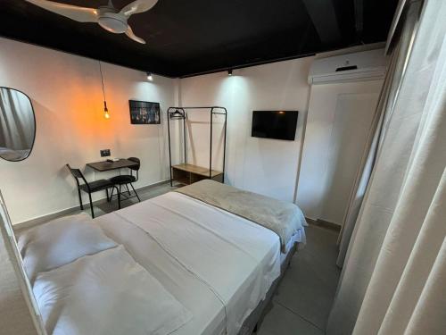 a bedroom with a bed and a table with a chair at Ház Portuguesa in Rio de Janeiro
