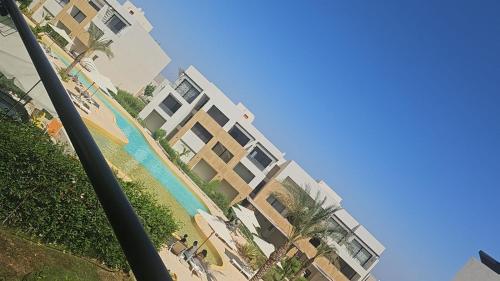 a tall building with a swimming pool next to a beach at Azha Ain Sokhna apartment in Ain Sokhna