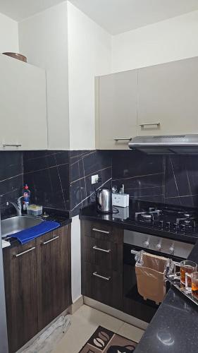 a kitchen with a sink and a stove top oven at Azha Ain Sokhna apartment in Ain Sokhna