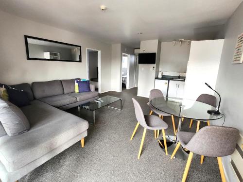 a living room with a couch and a table and chairs at Lugano Motor Lodge in Blenheim