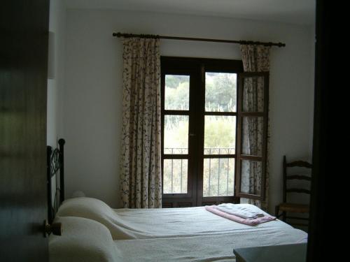 a bedroom with a bed and a window at La Parata Apartments in Moj&aacute;car
