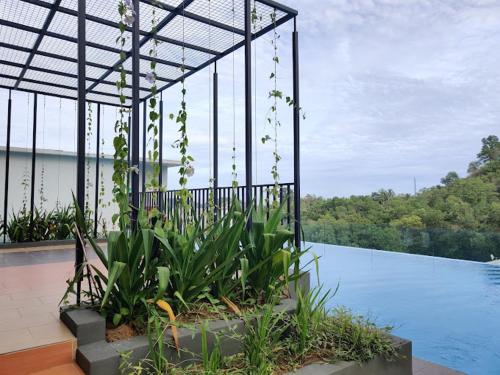 a metal structure with plants next to a body of water at The Avani Seroja Hills in Sepang