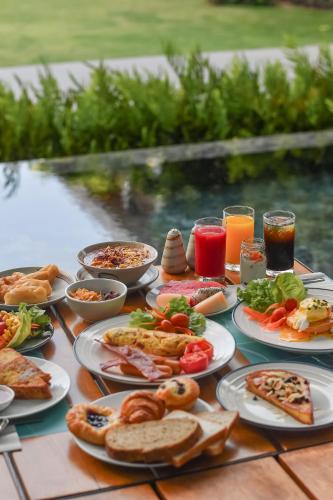 een tafel met borden met eten en drinken bij Renaissance Pattaya Resort & Spa in Na Jomtien