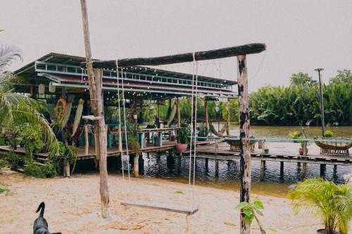 a building on the water with a bird in front of it at Funky Moon Kampot in Kampot