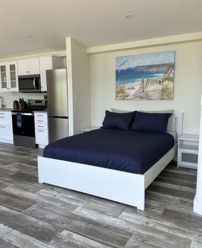 a bedroom with a large bed and a kitchen at Colindale Beach Villas -- MIni Villas in Port Hood