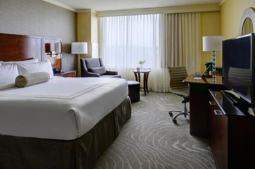 a hotel room with a bed and a television at Newport News Marriott at City Center in Newport News