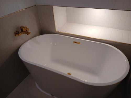 a white toilet in a bathroom with a light at Daeyeon Grandis Hotel in Busan